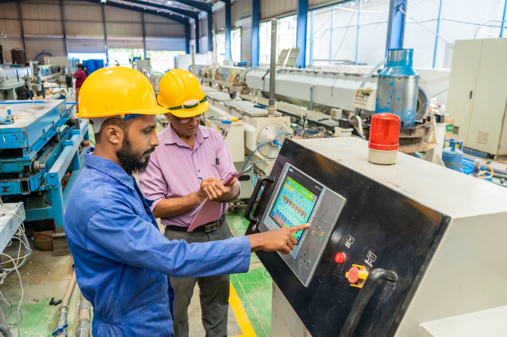 Technicians monitoring production on a digital control panel