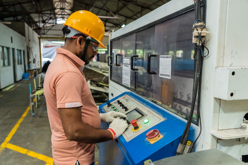 Operator running extrusion machinery on the factory floor