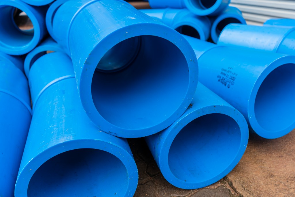 Stack of blue pressure pipes in outdoor storage