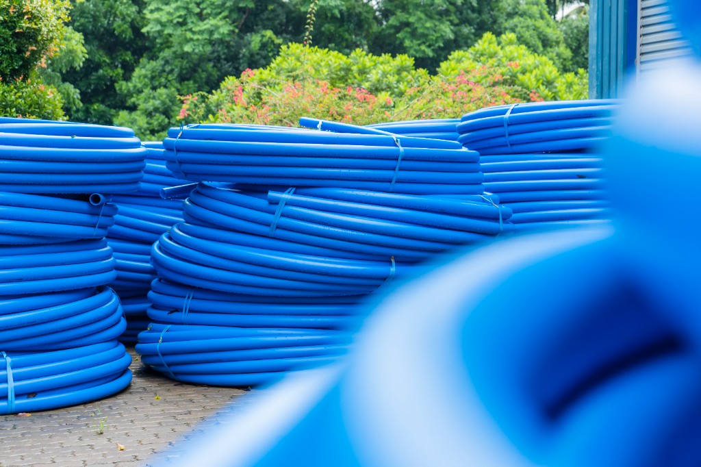 National PE pipe coils stored alongside greenery